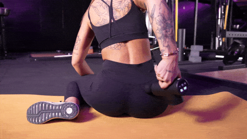 Използване на масажния пистолет в долната част на гърба