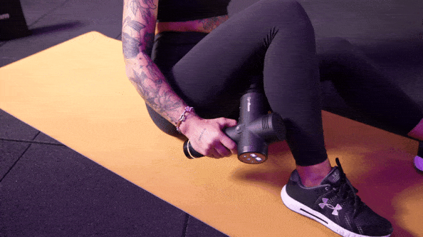 Използване на масажен пистолет за масаж на подколенните сухожилия